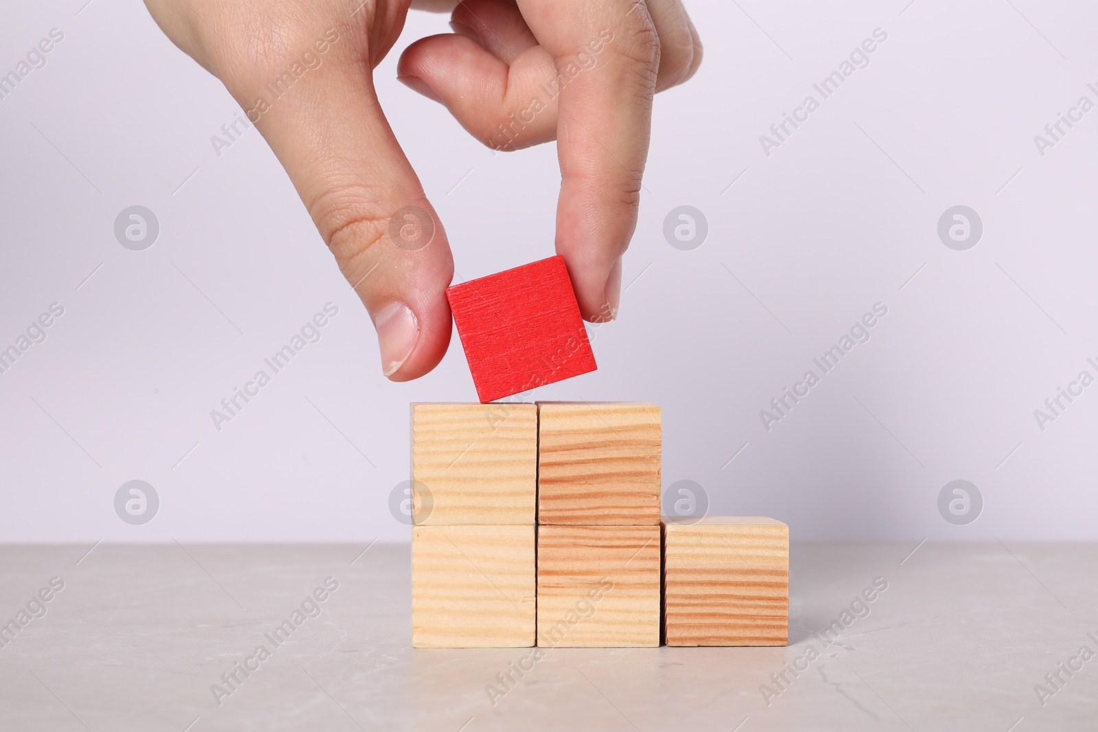 Photo of Woman with wooden cubes at light table, closeup