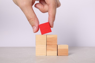 Photo of Woman with wooden cubes at light table, closeup