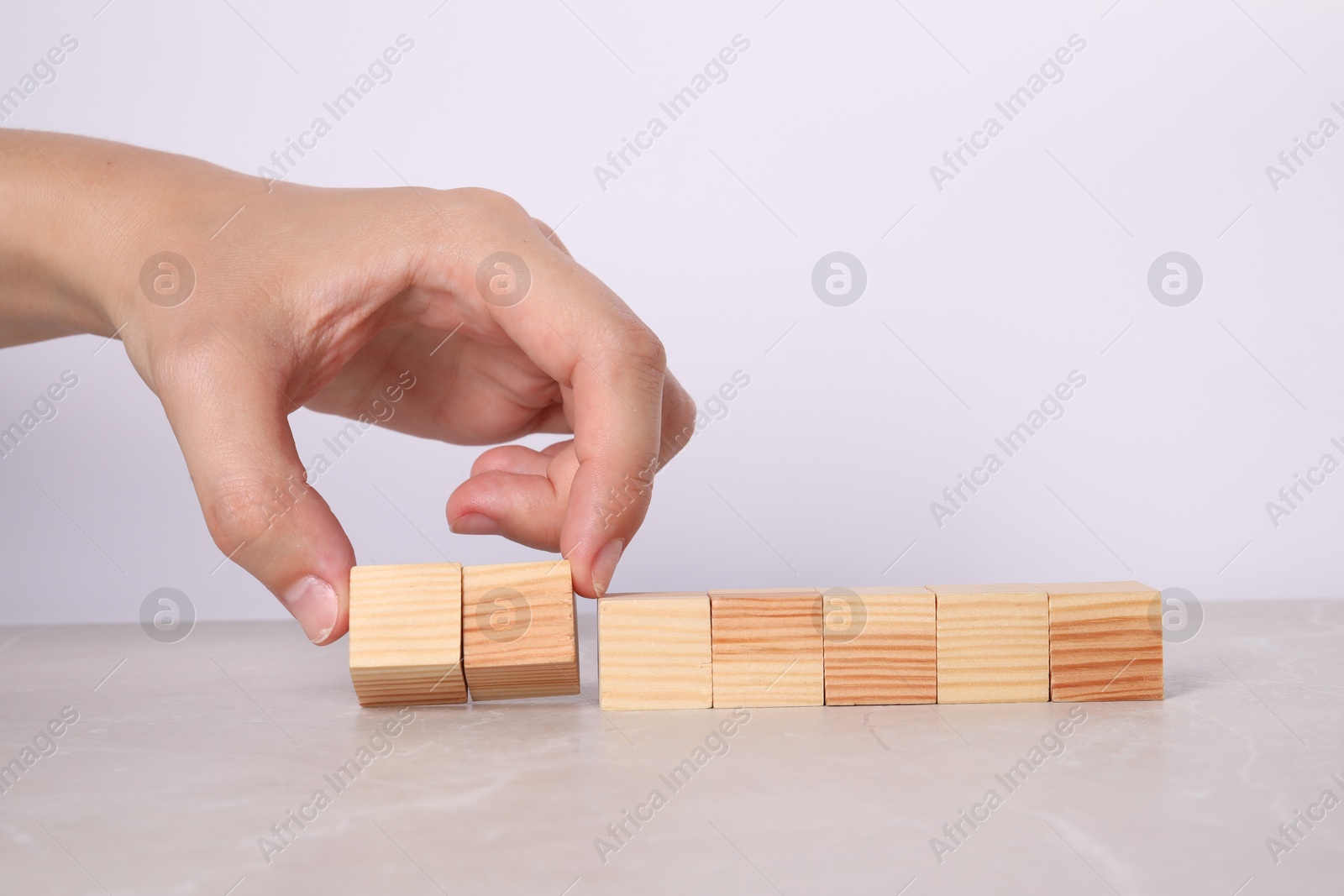 Photo of Woman with wooden cubes at light table, closeup