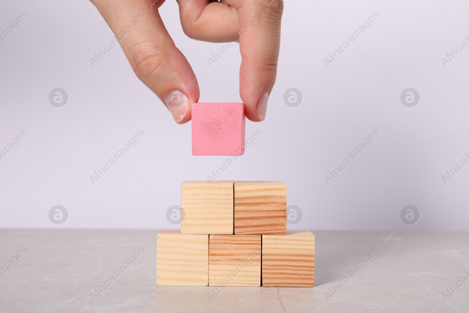 Photo of Woman with wooden cubes at light table, closeup