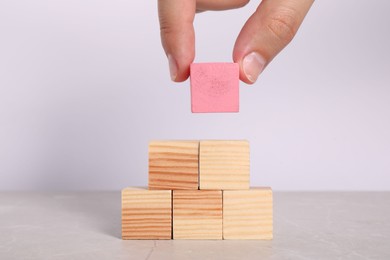 Photo of Woman with wooden cubes at light table, closeup