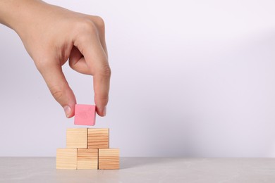 Photo of Woman with wooden cubes at light table, closeup. Space for text