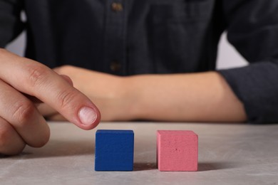 Photo of Woman with colorful cubes at light table, closeup