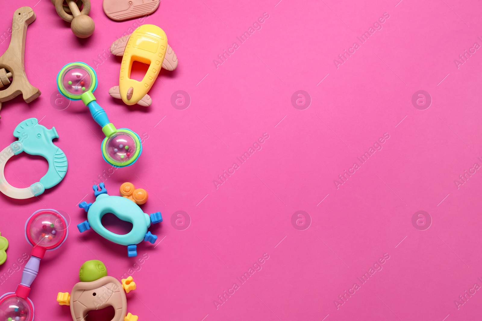 Photo of Different baby rattles on pink background, flat lay. Space for text