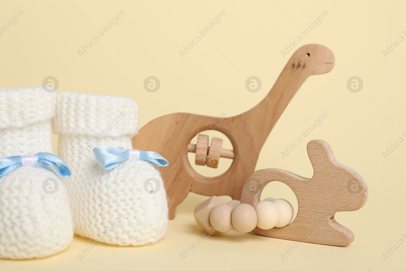 Photo of Baby rattles and booties on beige background