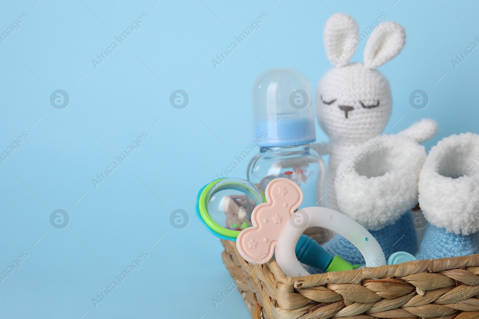 Photo of Baby accessories in box on light blue background, closeup. Space for text