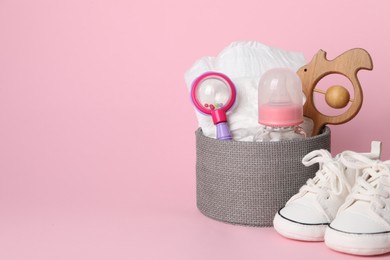 Box with different baby accessories on pink background. Space for text