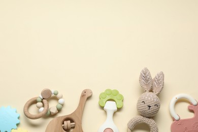 Photo of Different baby rattles on beige background, flat lay. Space for text