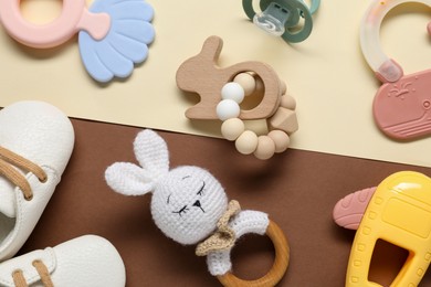 Photo of Different baby rattles and booties on color background, flat lay