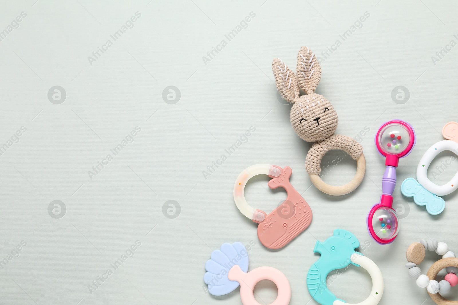 Photo of Different baby rattles on light background, flat lay. Space for text