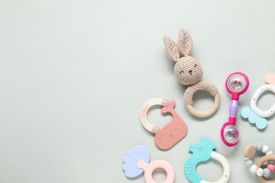 Different baby rattles on light background, flat lay. Space for text