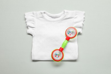 Photo of Baby rattle and body on light background, top view