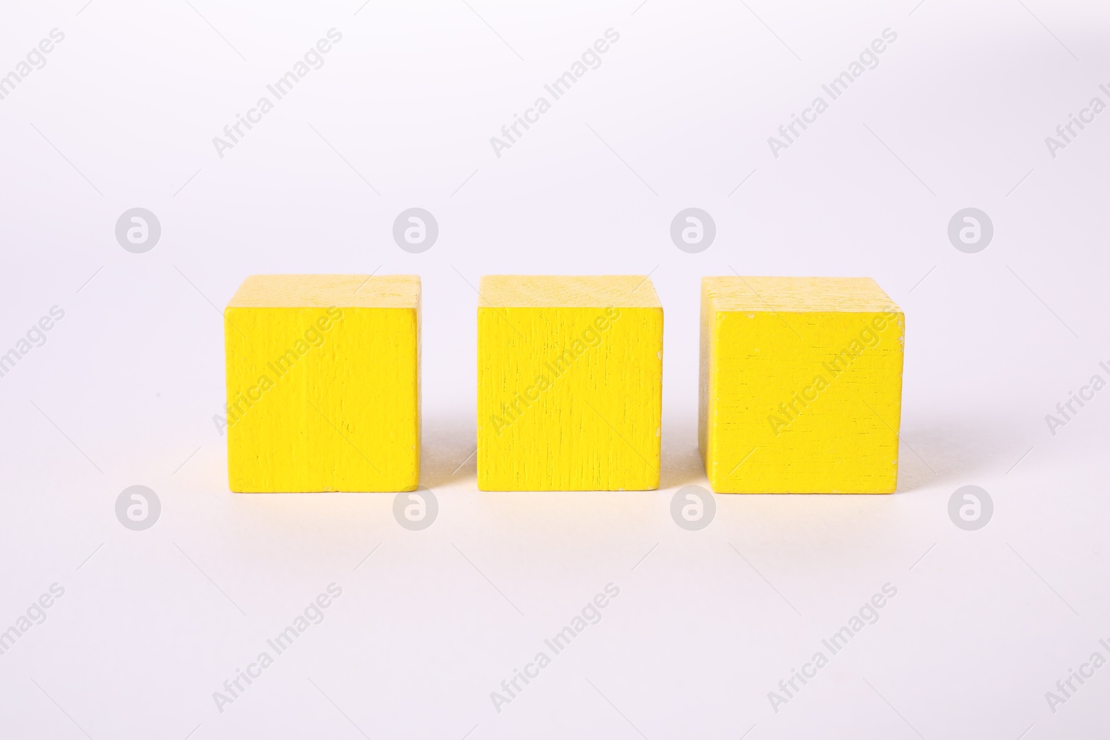 Photo of Many yellow wooden cubes isolated on white