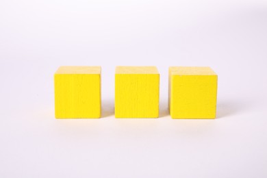 Photo of Many yellow wooden cubes isolated on white