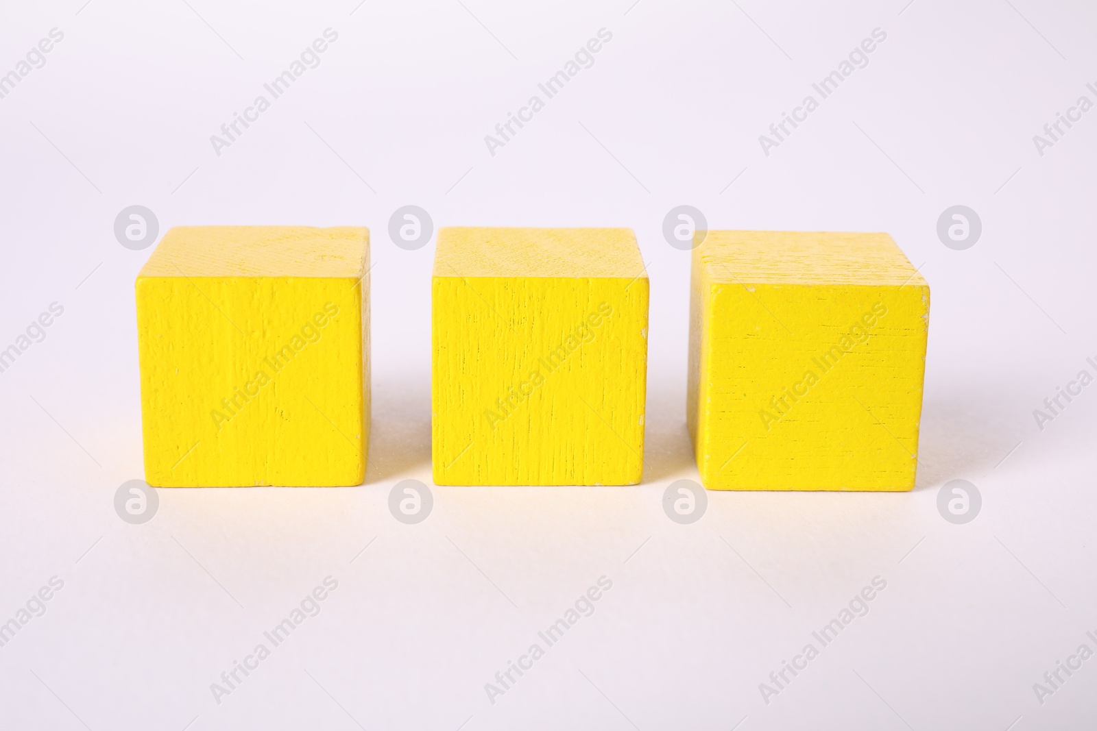 Photo of Many yellow wooden cubes isolated on white