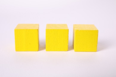 Photo of Many yellow wooden cubes isolated on white