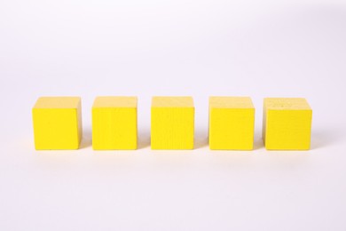 Photo of Many yellow wooden cubes isolated on white