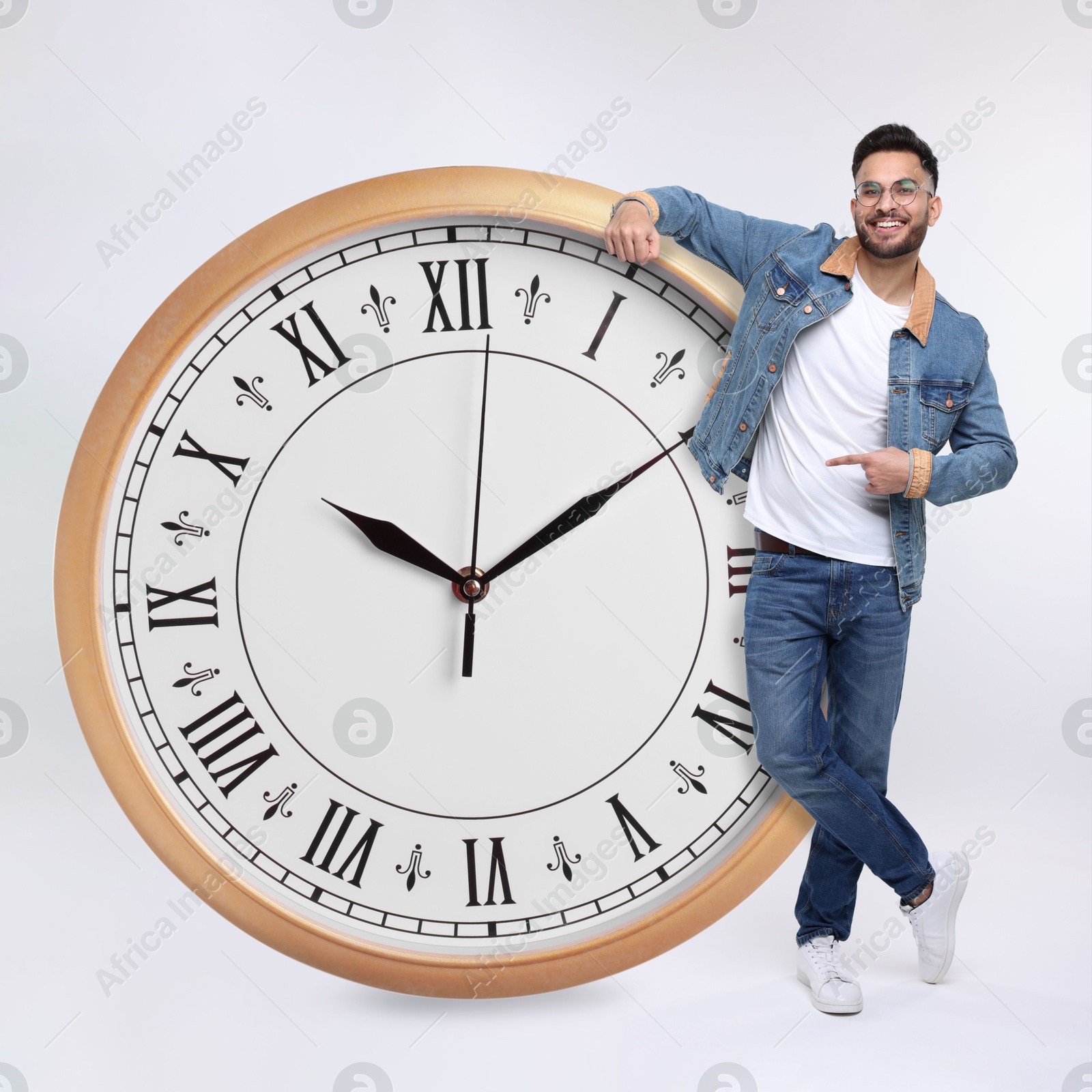 Image of Man pointing at big clock on white background