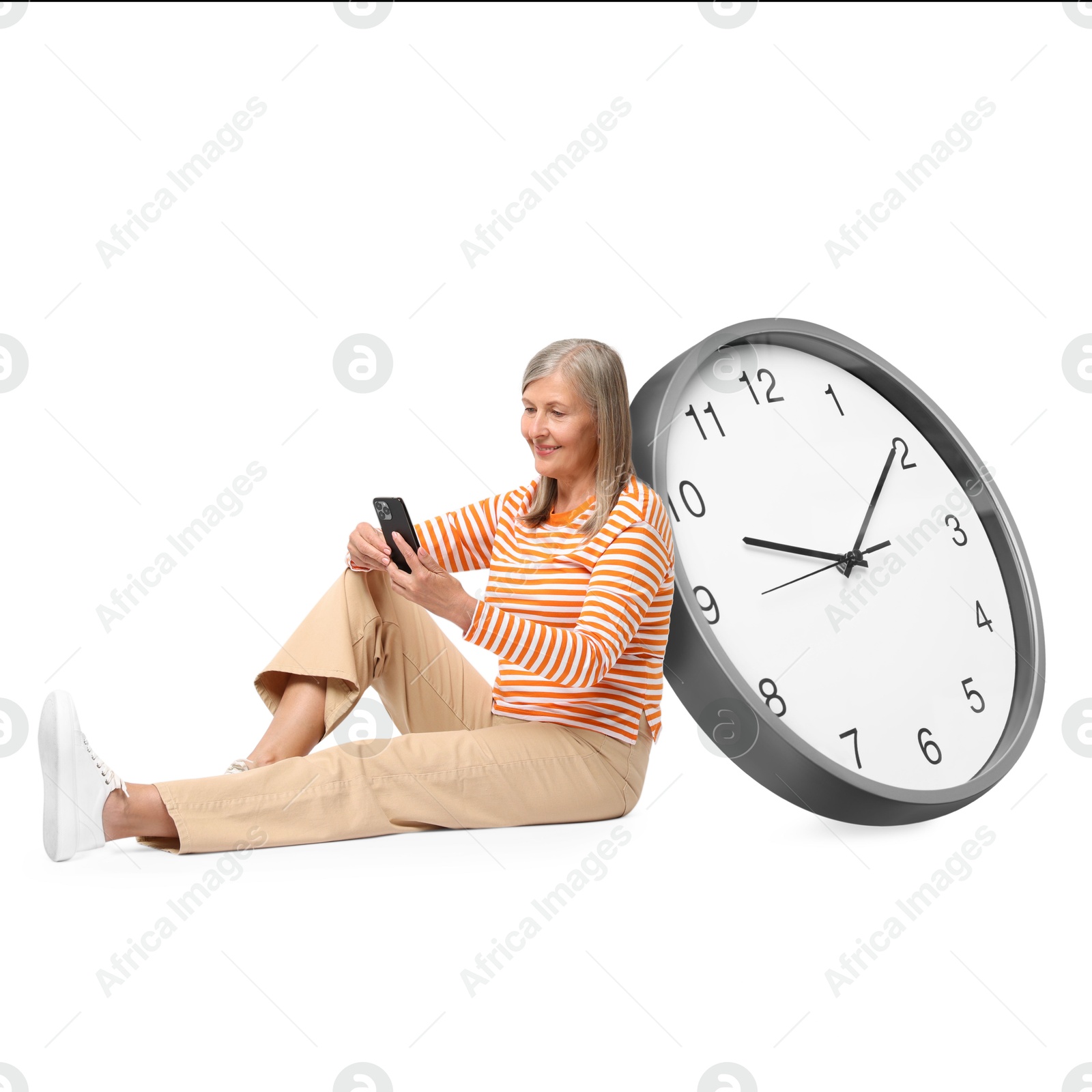 Image of Mature woman with smartphone and big clock on white background