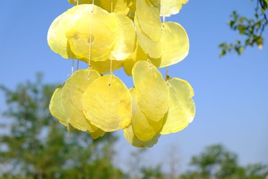 Photo of Beautiful wind chimes against blue sky, closeup