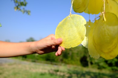 Woman enjoying beautiful wind chimes outdoors, closeup