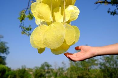 Photo of Woman enjoying beautiful wind chimes outdoors, closeup