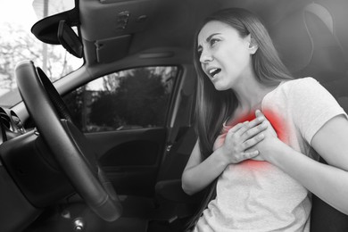 Image of Young woman suffering from heart pain while driving in car