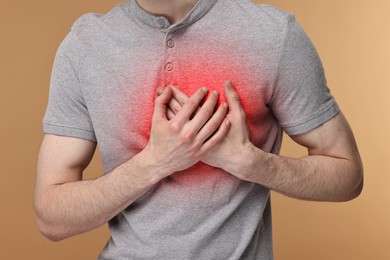 Image of Man suffering from pain in chest on dark beige background, closeup. Heart disease