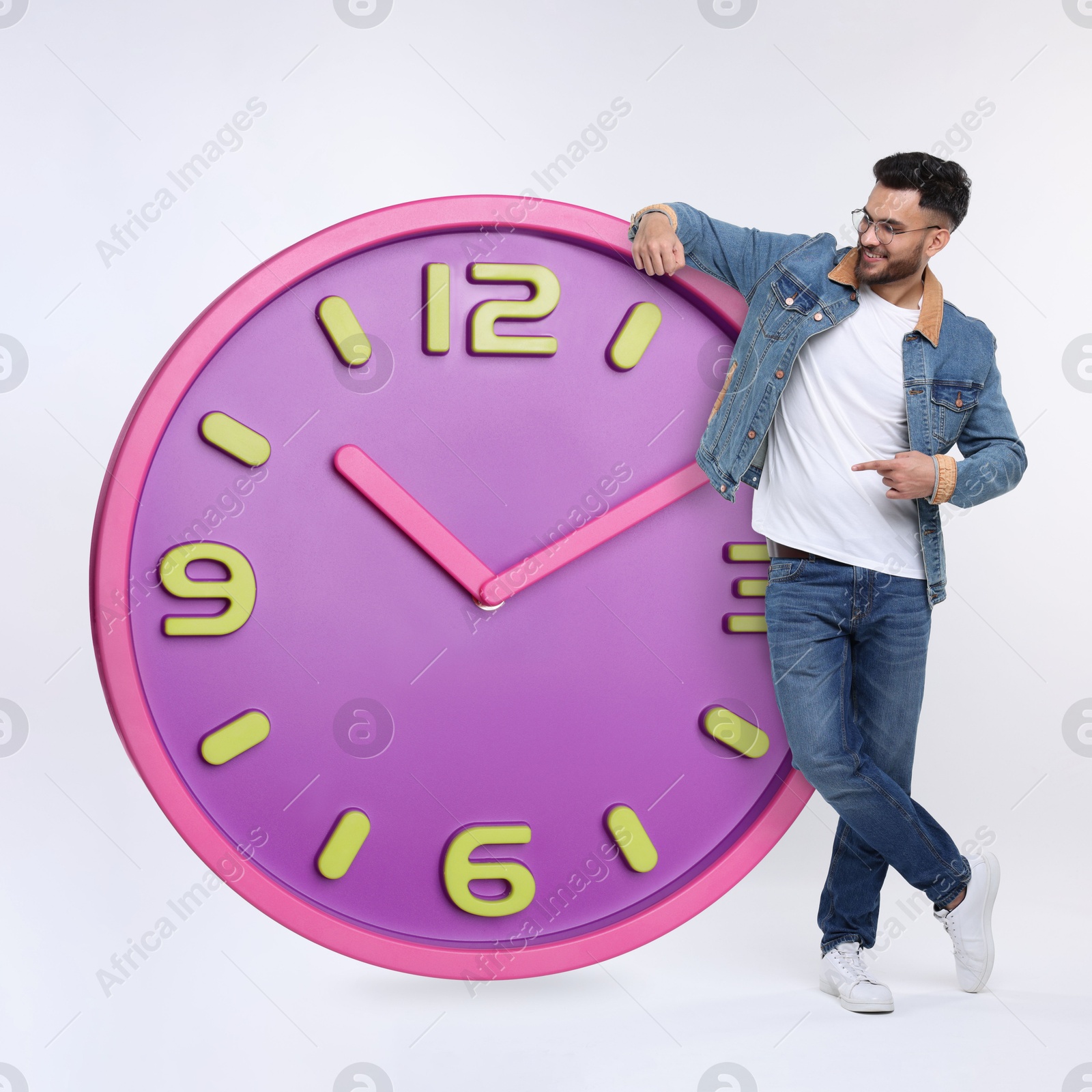 Image of Man pointing at big clock on white background