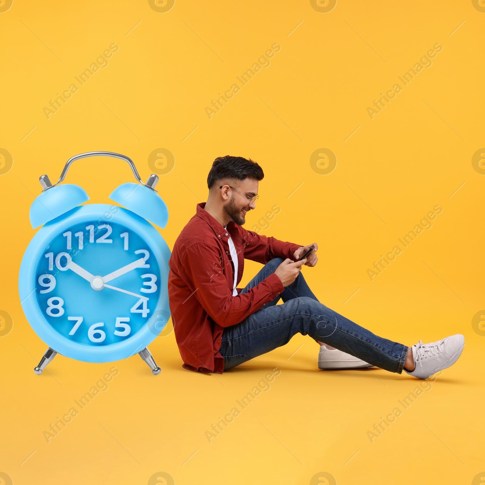 Image of Man with smartphone and big clock on orange background