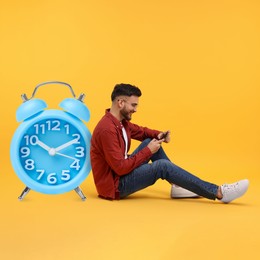 Man with smartphone and big clock on orange background