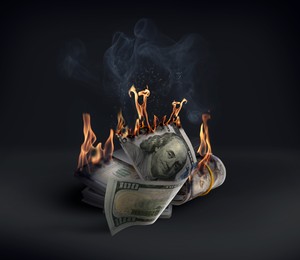 Image of Dollar banknotes burning in darkness. Financial crisis