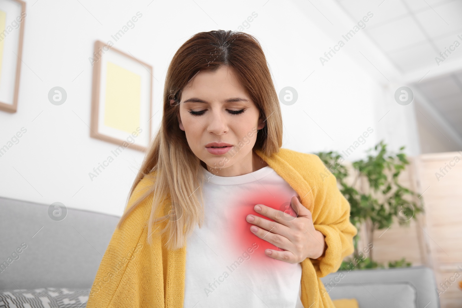 Image of Woman suffering from pain in chest at home. Heart disease