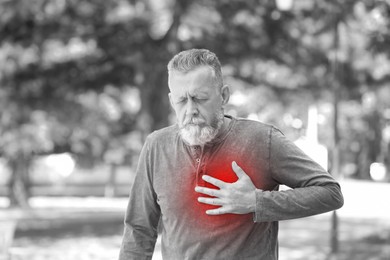 Image of Senior man suffering from pain in chest outdoors. Heart disease