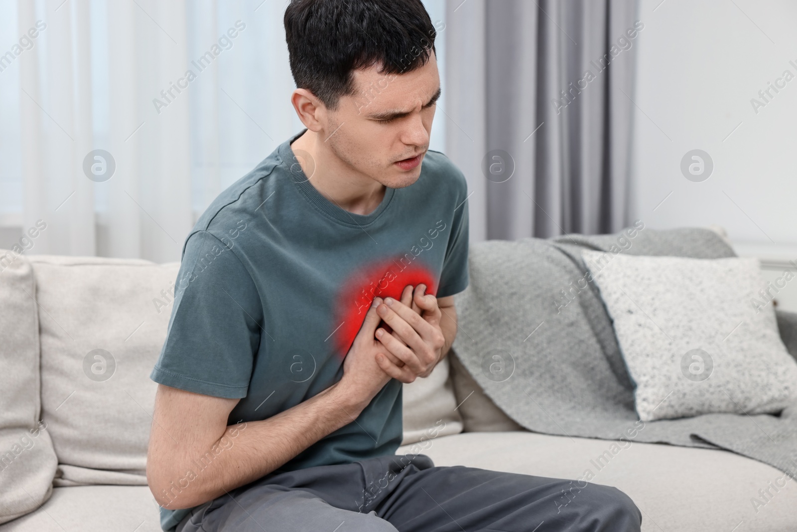 Image of Man suffering from pain in chest at home. Heart disease