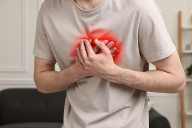 Image of Man suffering from pain in chest at home, closeup. Heart disease