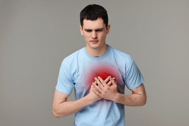 Image of Man suffering from pain in chest on grey background. Heart disease