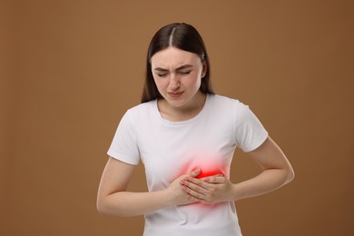 Image of Woman suffering from pain in chest on brown background. Heart disease