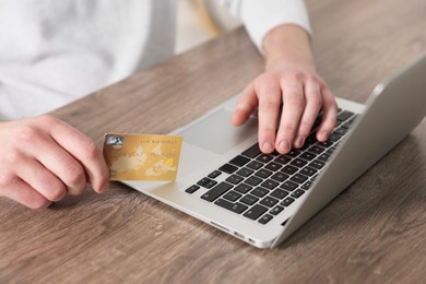 Photo of Online banking. Man with credit card and laptop paying purchase at table, closeup