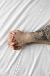 Photo of Lovely couple holding hands in bed, top view