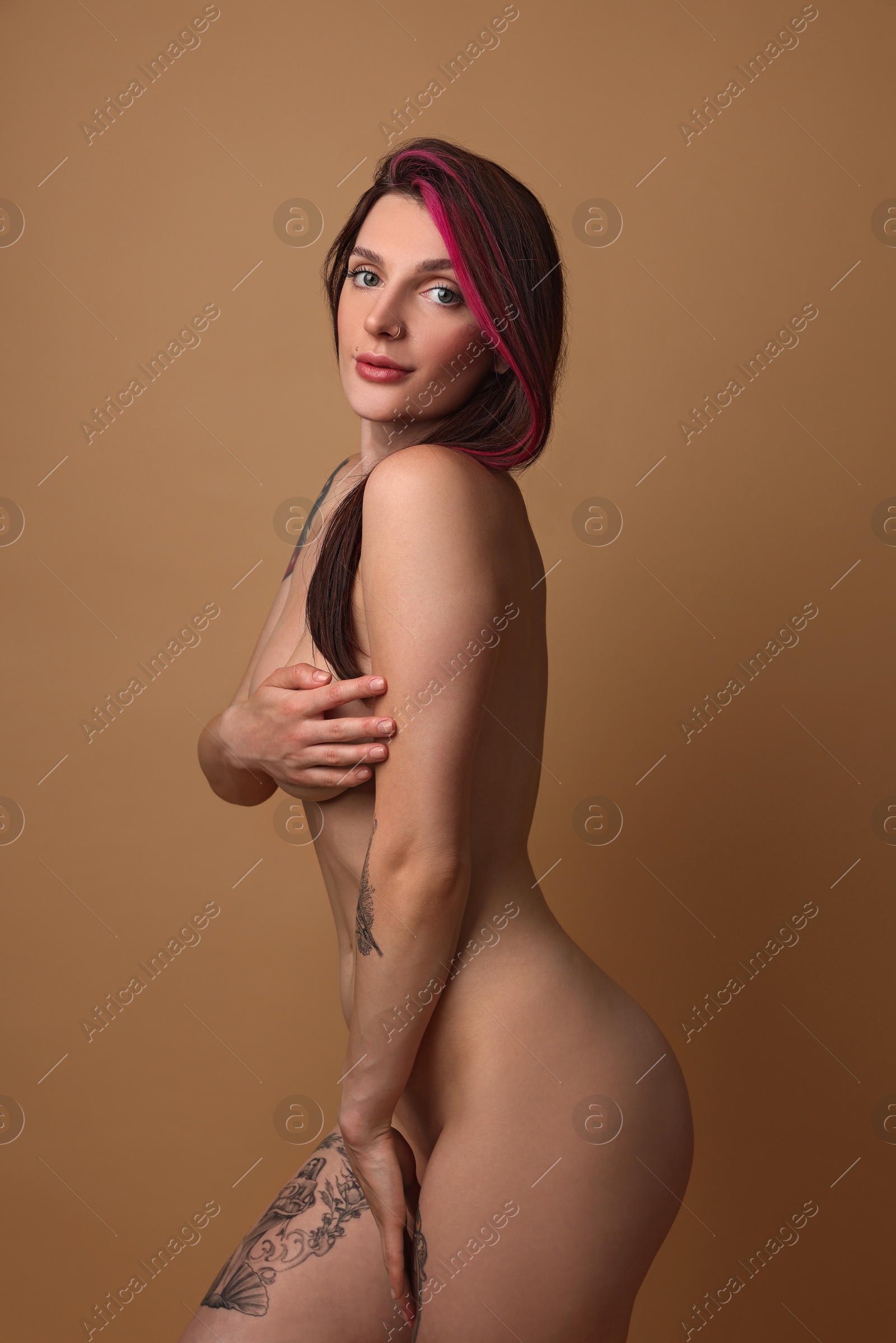 Photo of Sexy nude woman posing on beige background