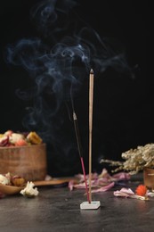 Photo of Aromatic incense sticks smoldering on grey table