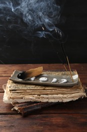 Photo of Aromatic incense sticks smoldering on wooden table