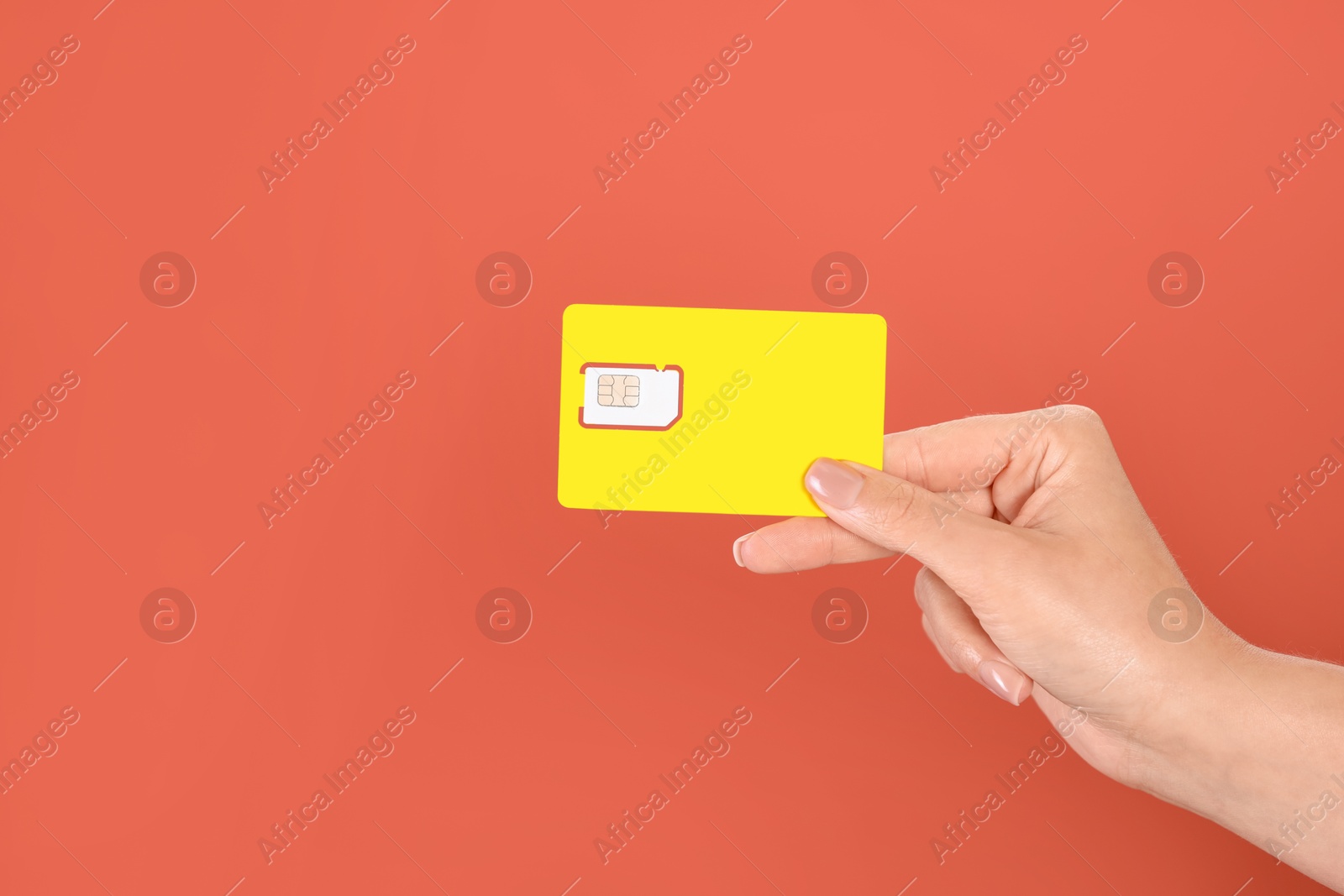 Photo of Woman holding SIM card on terracotta background, closeup. Space for text