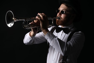 Photo of Professional musician playing trumpet on black background