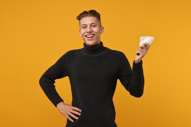 Photo of Happy young man with tissue on orange background
