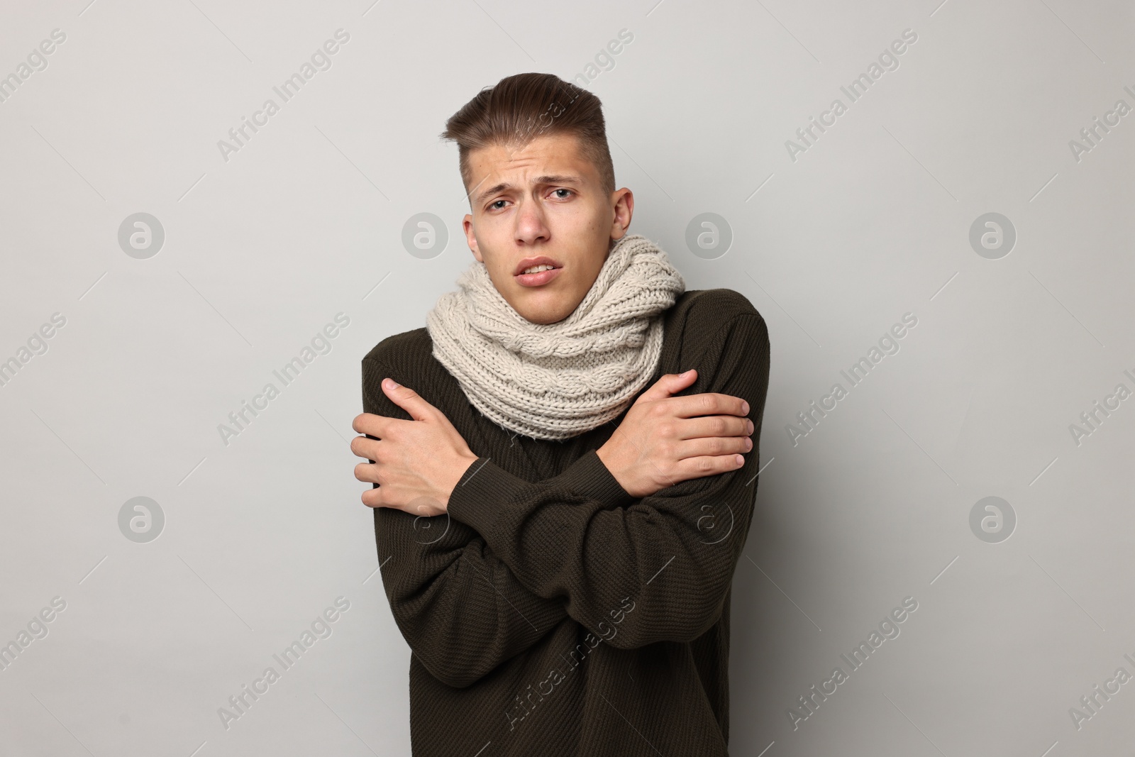 Photo of Sick man suffering from cold symptoms on light grey background