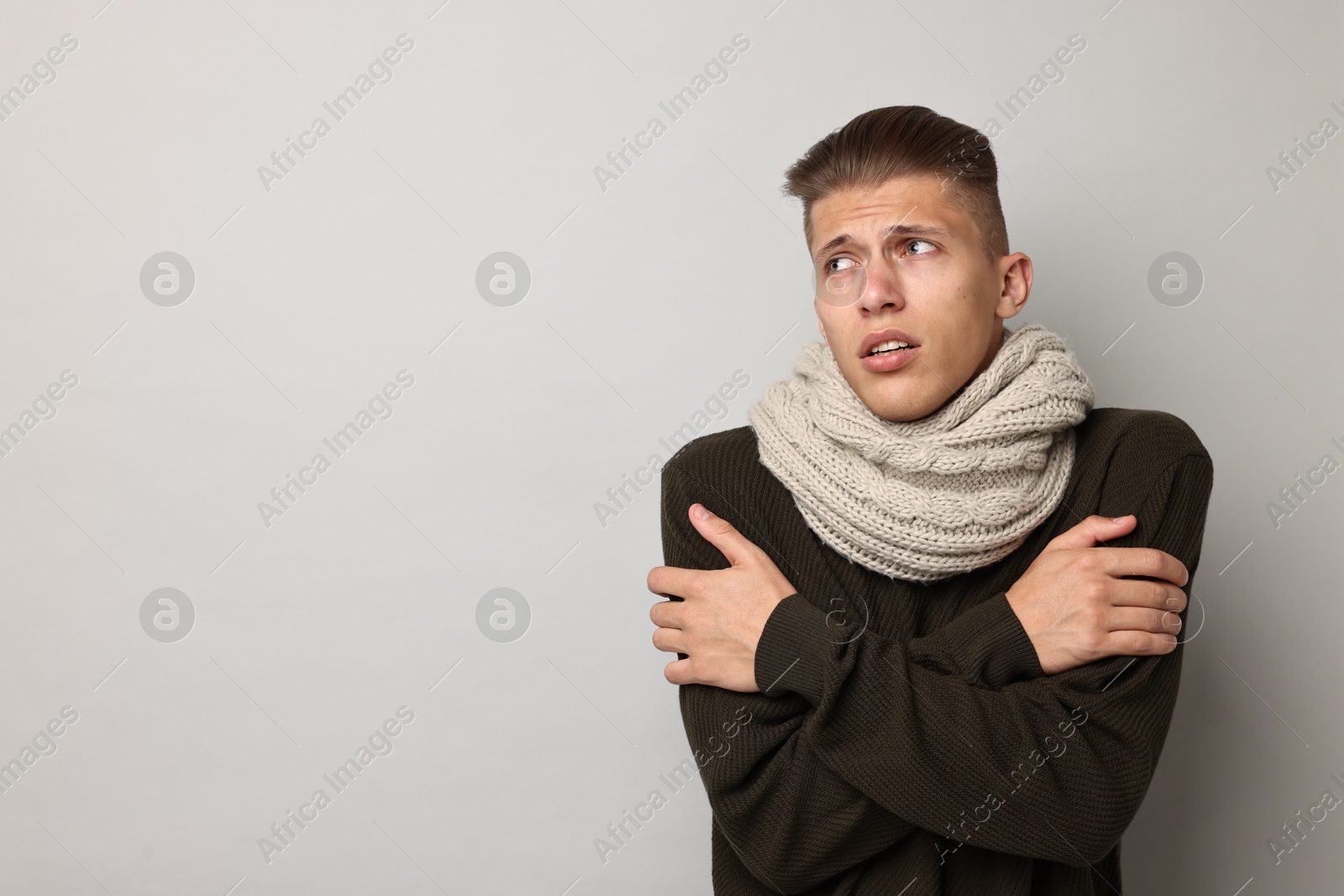 Photo of Sick man suffering from cold symptoms on light grey background, space for text