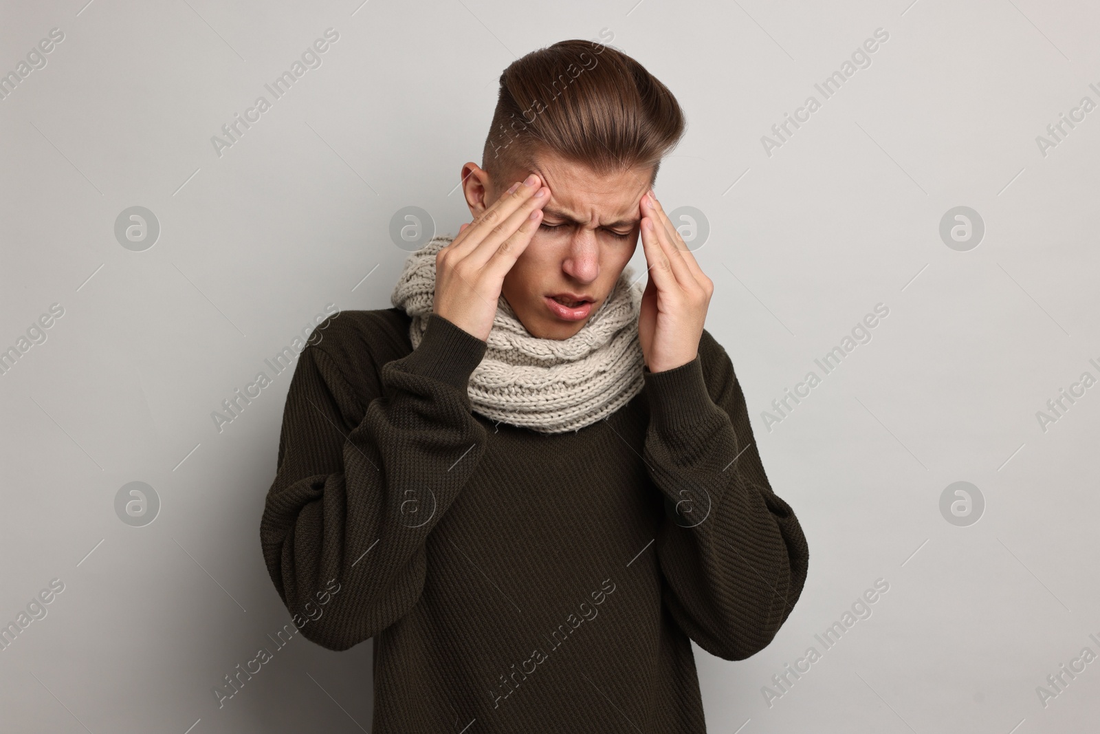 Photo of Sick man suffering from cold symptoms on light grey background