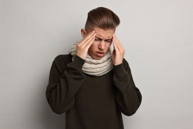 Photo of Sick man suffering from cold symptoms on light grey background